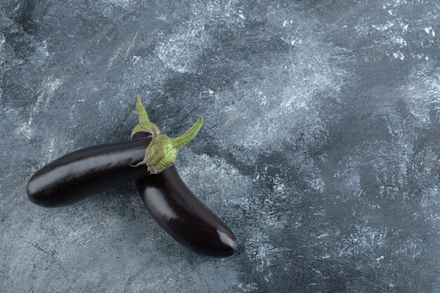 Deux aubergines mûres fraîches sur la vue de dessus de fond gris.