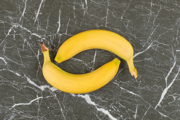 Deux bananes biologiques fraîches sur pierre noire