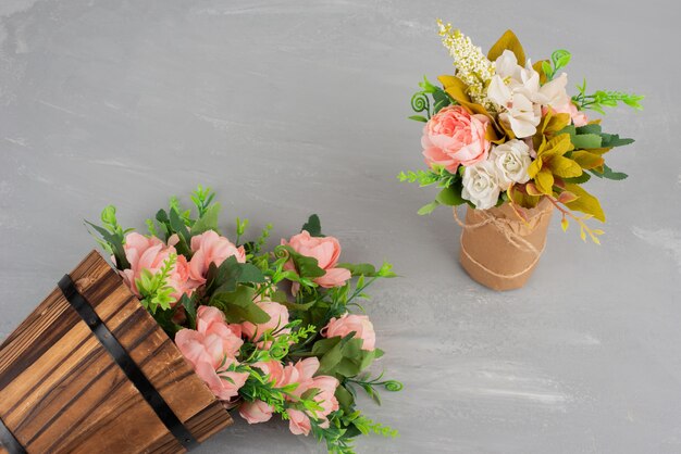 Deux beaux bouquets de fleurs sur une surface grise