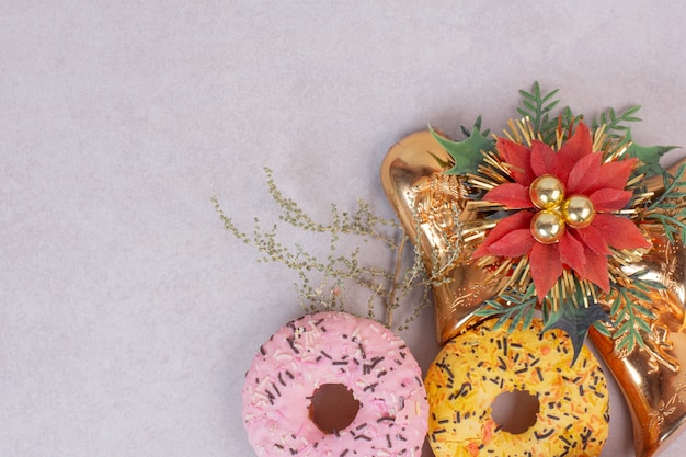 Deux beignets sucrés colorés sur une surface blanche