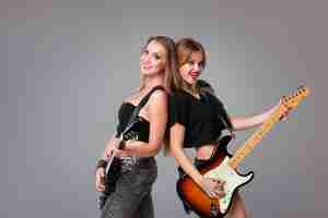 Photo gratuite deux belles femmes jouant de la guitare