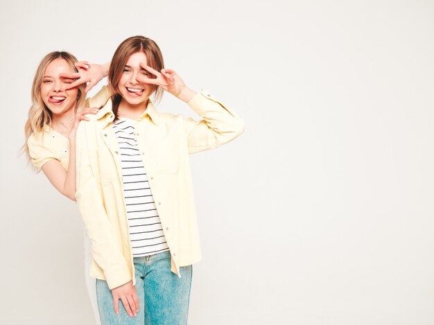 Deux belles jeunes femmes hipster souriantes blondes dans des vêtements d'été à la mode