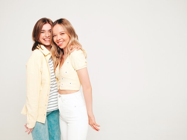 Deux belles jeunes femmes hipster souriantes blondes dans des vêtements d'été à la mode
