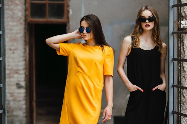 Deux belles jeunes filles posant contre un bâtiment abandonné