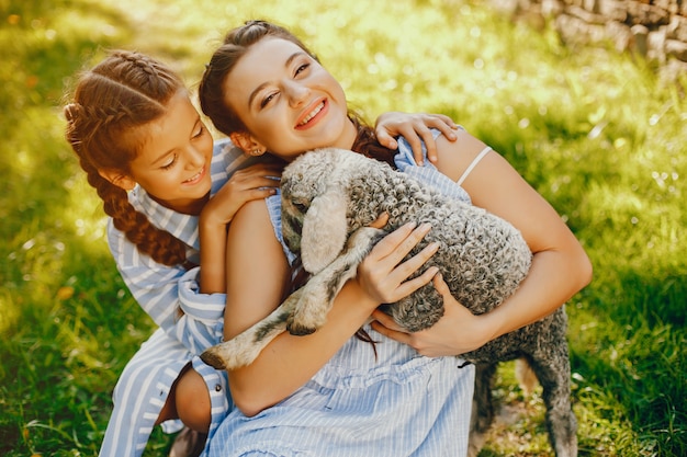 Deux belles et mignonnes filles en robes bleues avec de belles coiffures et de maquillage assis