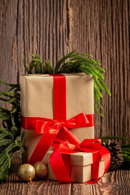 Deux boîtes de cadeau avec noeud de ruban rouge sur fond de bois