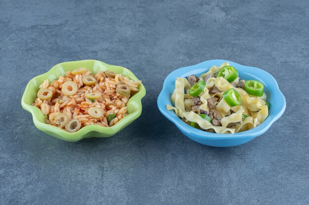 Deux bols de riz et de pâte bouillie sur une table en marbre.