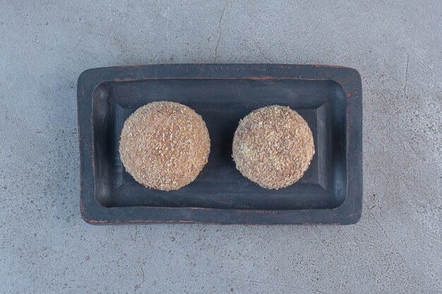 Deux boules de truffes savoureuses placées sur une plaque noire.