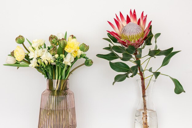 Deux bouquets de fleurs sur fond blanc dans des vases