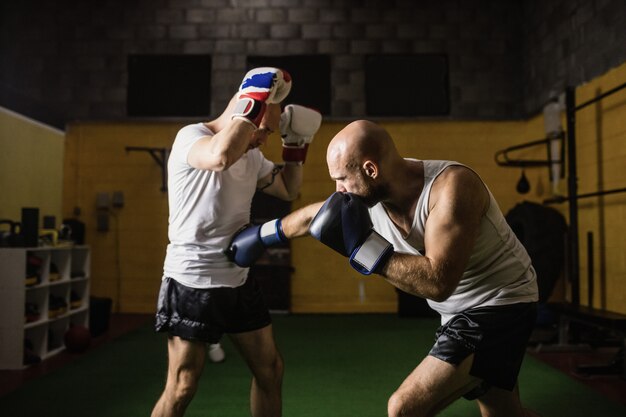 Deux boxeurs pratiquant la boxe en studio de remise en forme