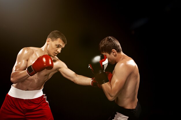 Deux boxeurs professionnels sur fond noir,