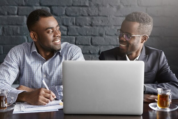 Photo gratuite deux cadres afro-américains prospères et expérimentés souriant joyeusement