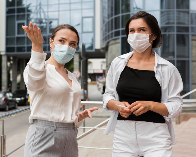 Deux collègues à l'extérieur pendant la pandémie portant des masques