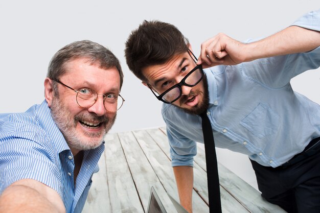 Deux collègues leur prenant la photo en s'asseyant au bureau