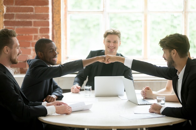 Deux collègues multiethniques positifs se donnent la main.