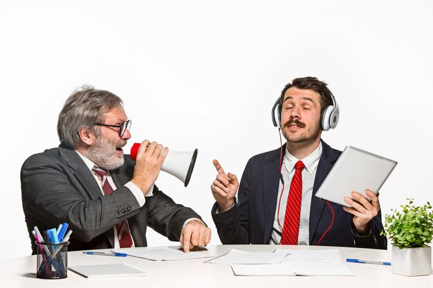 Les deux collègues travaillant ensemble au bureau sur blanc.