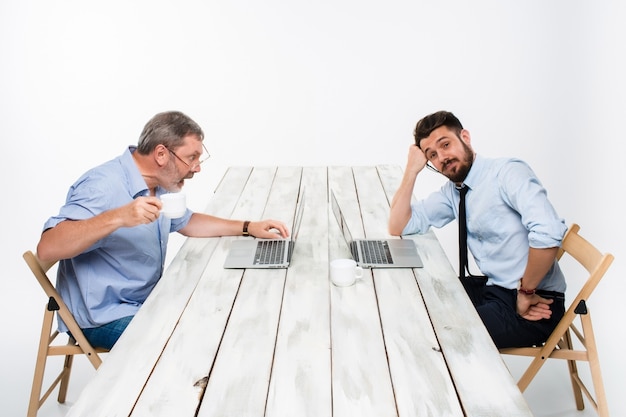 Photo gratuite les deux collègues travaillant ensemble au bureau sur fond gris