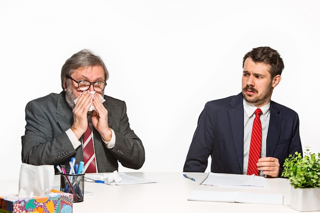 Les deux collègues travaillant ensemble au bureau sur studio blanc