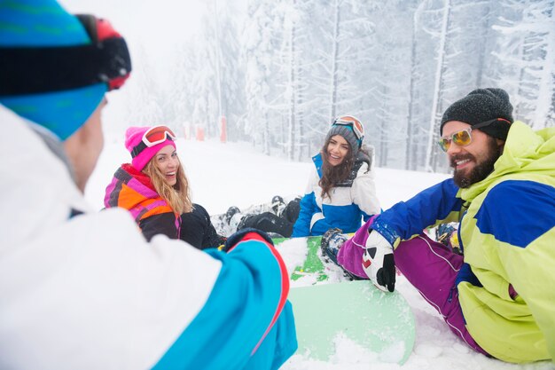 Deux couples s'amusant et faisant du snowboard