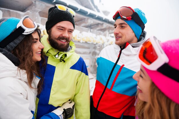 Deux couples s'amusant et faisant du snowboard