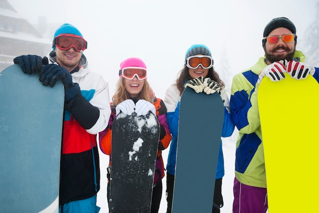 Photo gratuite deux couples s'amusant et faisant du snowboard