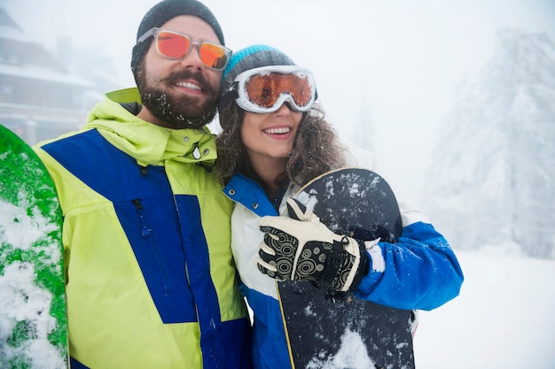 Photo gratuite deux couples s'amusant et faisant du snowboard