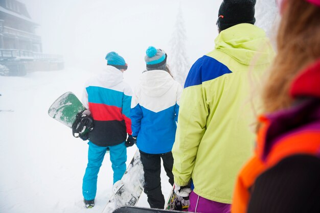 Deux couples s'amusant et faisant du snowboard