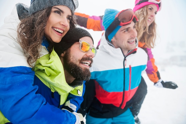 Deux couples s'amusant et faisant du snowboard