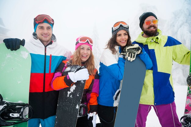 Deux couples s'amusant et faisant du snowboard