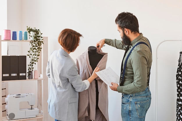 Photo gratuite deux créateurs de mode en atelier avec forme de robe