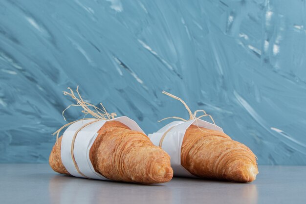 Deux croissants noués sur le fond de marbre. Photo de haute qualité