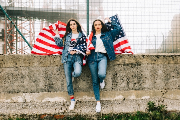 Photo gratuite deux dames posant contre la clôture