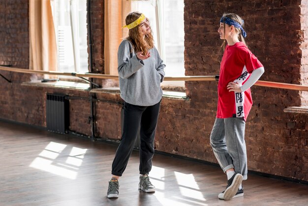 Deux danseuses debout dans le studio se parlant