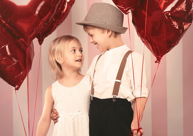 Deux enfants amoureux debout avec les ballons