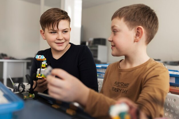 Deux enfants construisant un robot à l'aide de composants électroniques