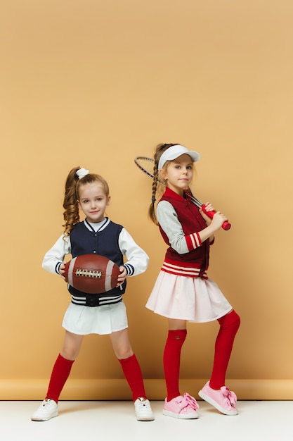 Deux enfants heureux et beaux montrent un sport différent. Concept d'émotions.