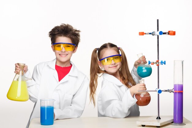 Deux enfants mignons à la leçon de chimie faisant des expériences