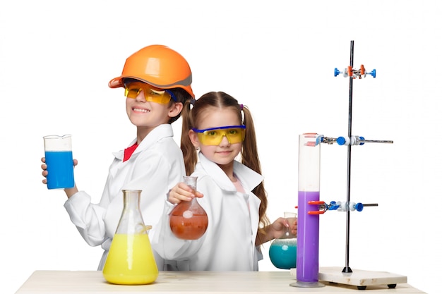 Deux enfants mignons à la leçon de chimie faisant des expériences