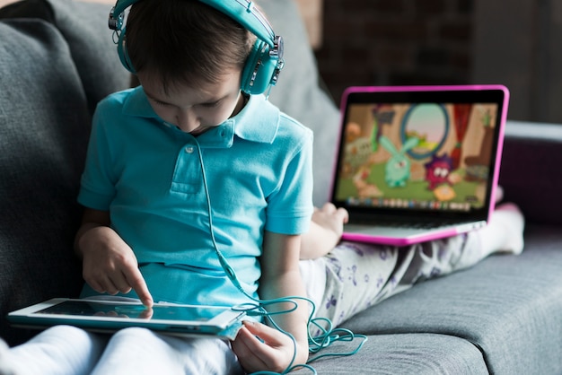 Deux enfants avec un ordinateur portable et une tablette