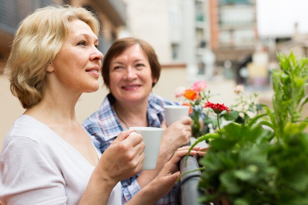 Deux femmes boivent du thé sur le balcon