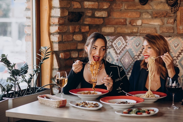 Deux femmes mangeant des pâtes dans un restaurant italien