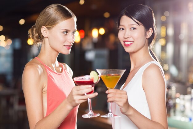 Deux femmes souriantes avec Cocktails en restaurant