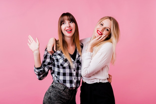 Deux femmes souriantes étreignant et debout ensemble