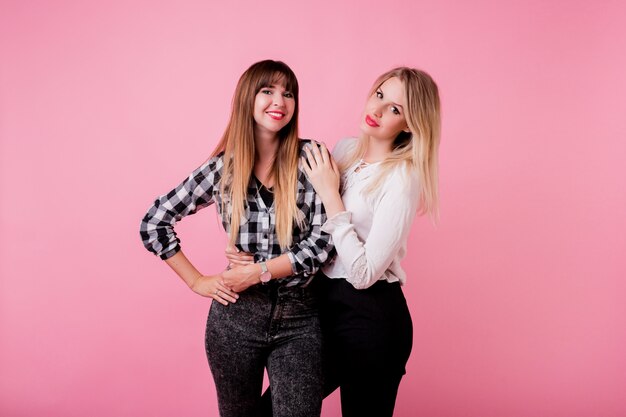 Deux femmes souriantes étreignant et debout ensemble