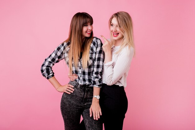 Deux femmes souriantes étreignant et debout ensemble