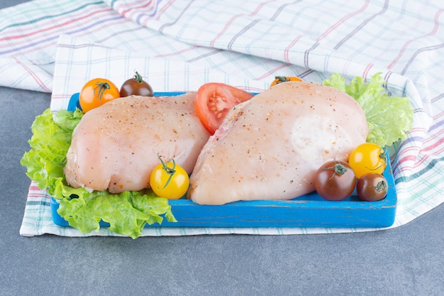 Photo gratuite deux filets de poulet sur plaque bleue.