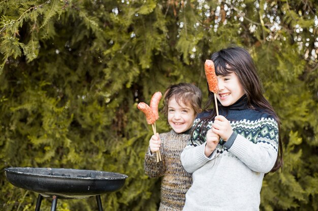 Deux filles heureuse tenant des saucisses