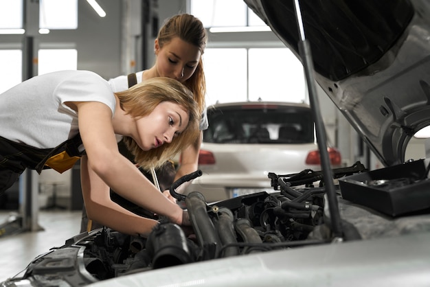 Deux filles mécaniciens et réparateur automobile.