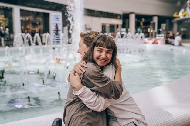 Deux filles s'amusent dans le centre commercial, à côté d'une fontaine