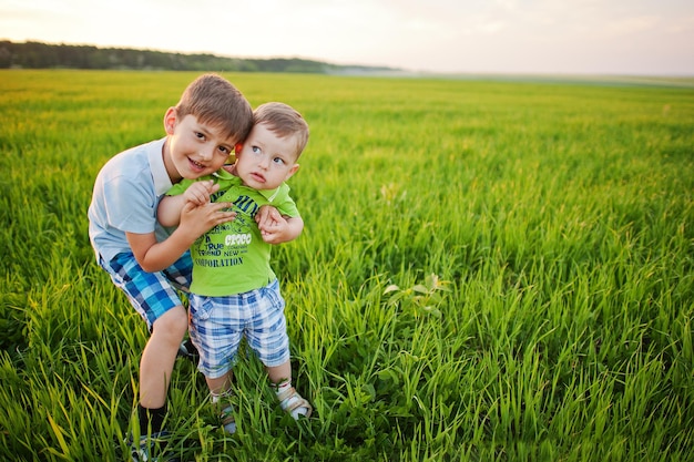 Deux frères dans un champ d'herbe verte